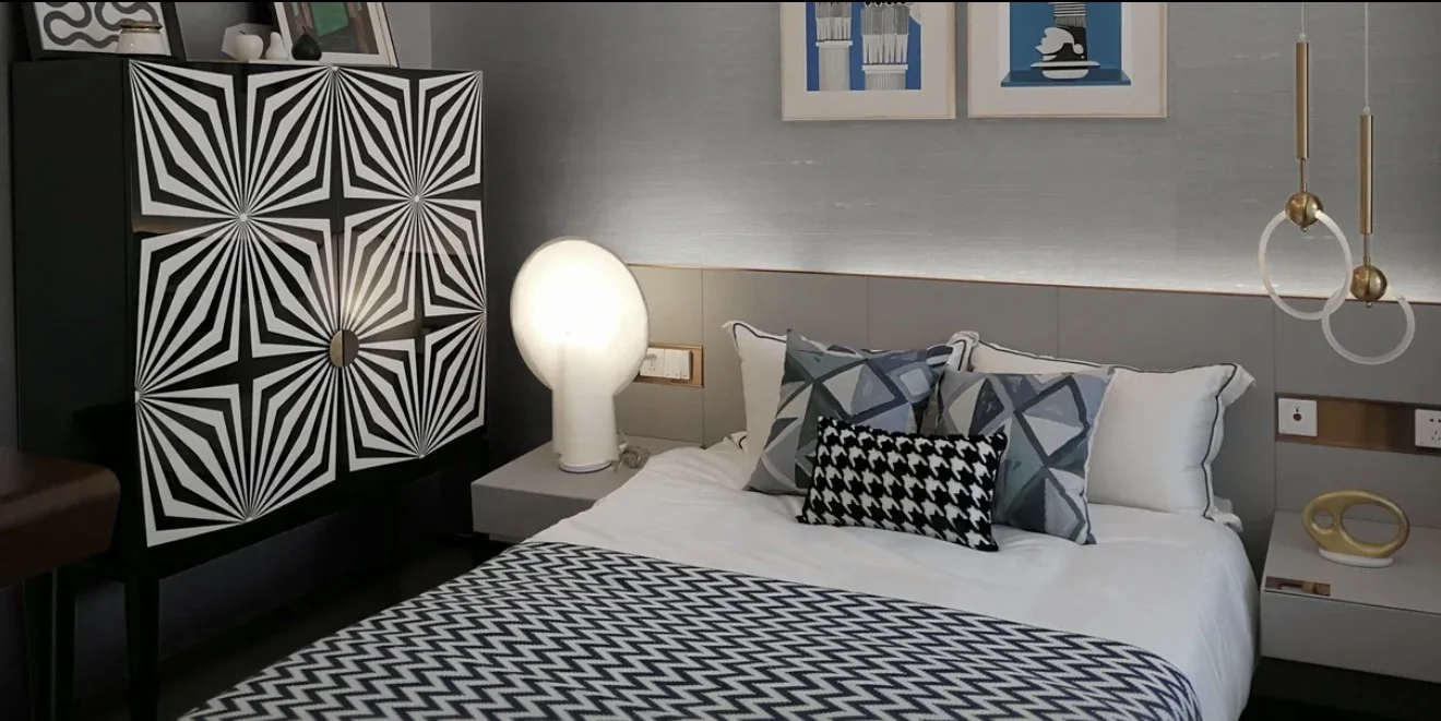 Bedroom with a pale textured cotton wallcovering behind an upholstered bed and soft neutral bedding
