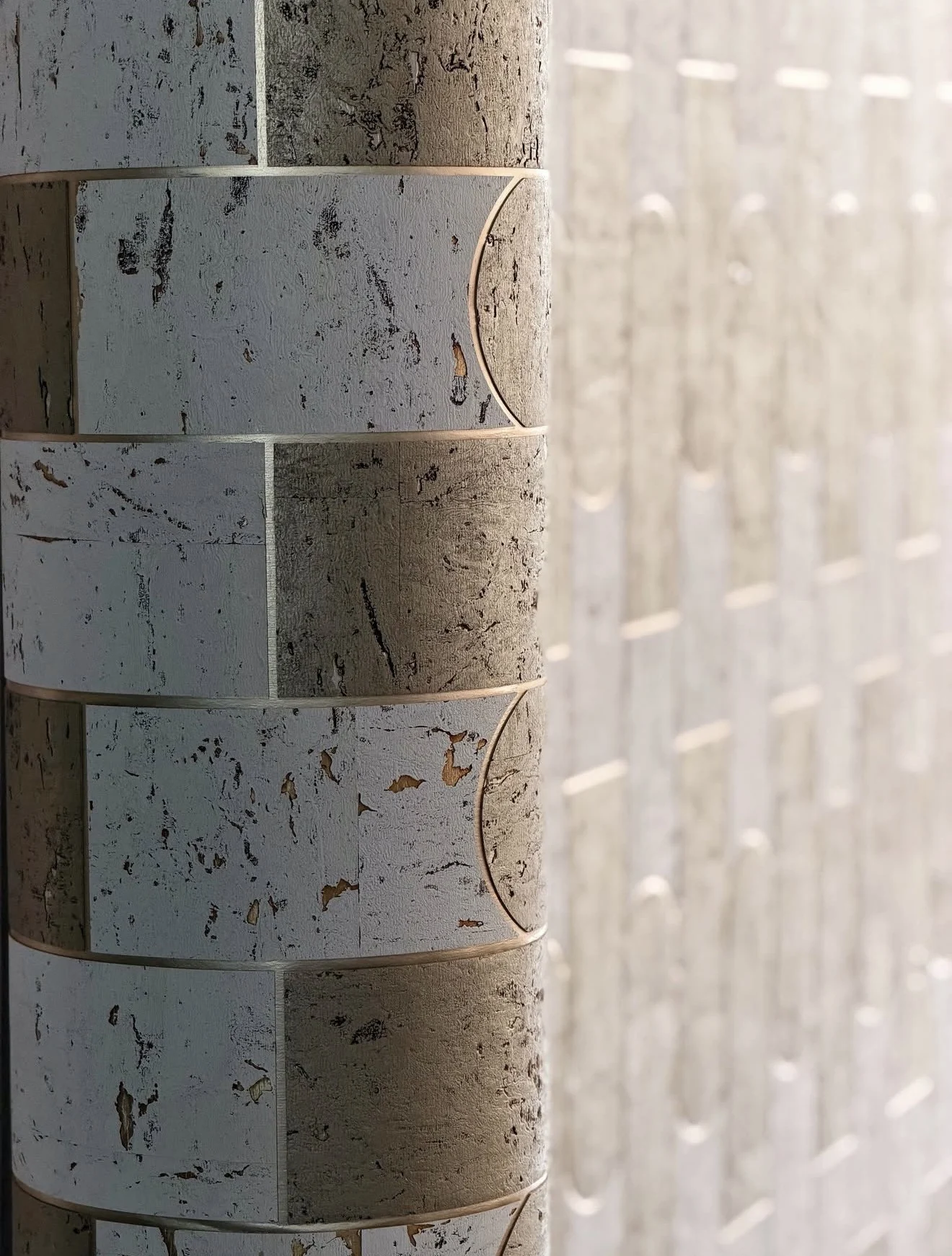 Rolled pale textured wallcovering with irregular natural markings and fine horizontal lines