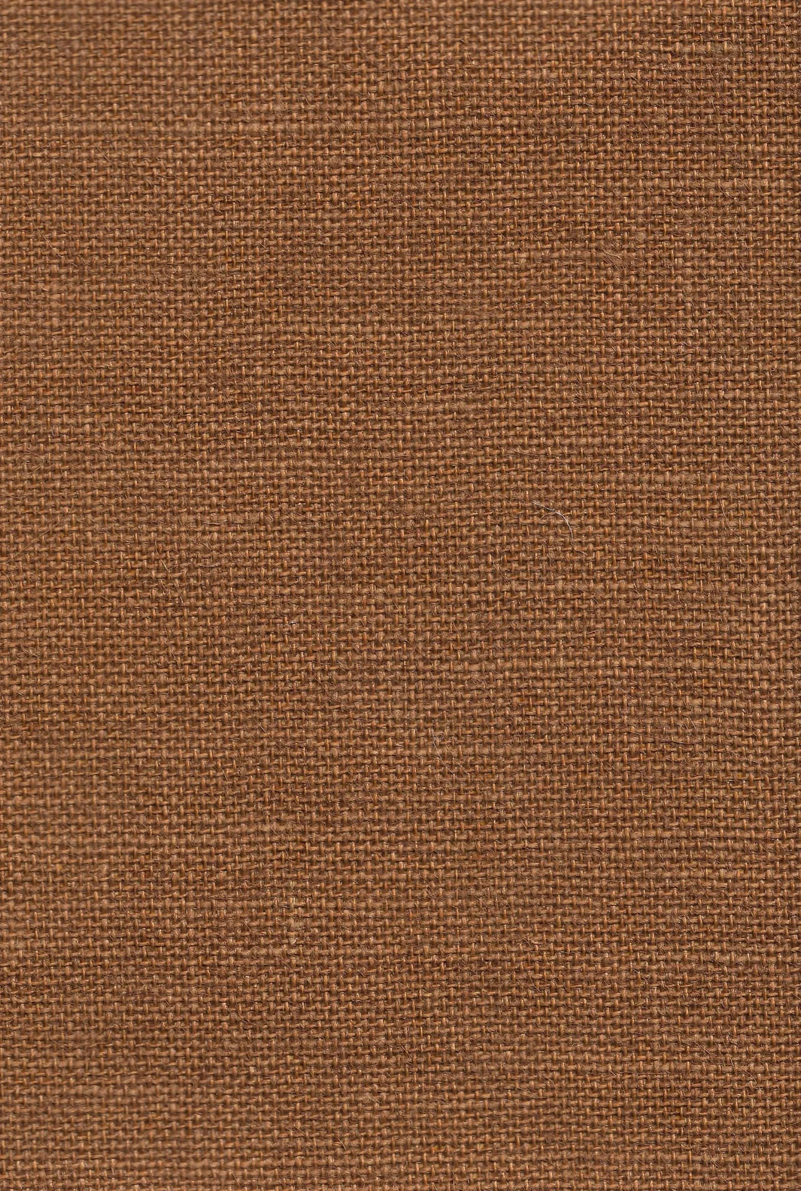 Close-up of a warm tan jute wallcovering showing its open basket weave and natural fibre strands