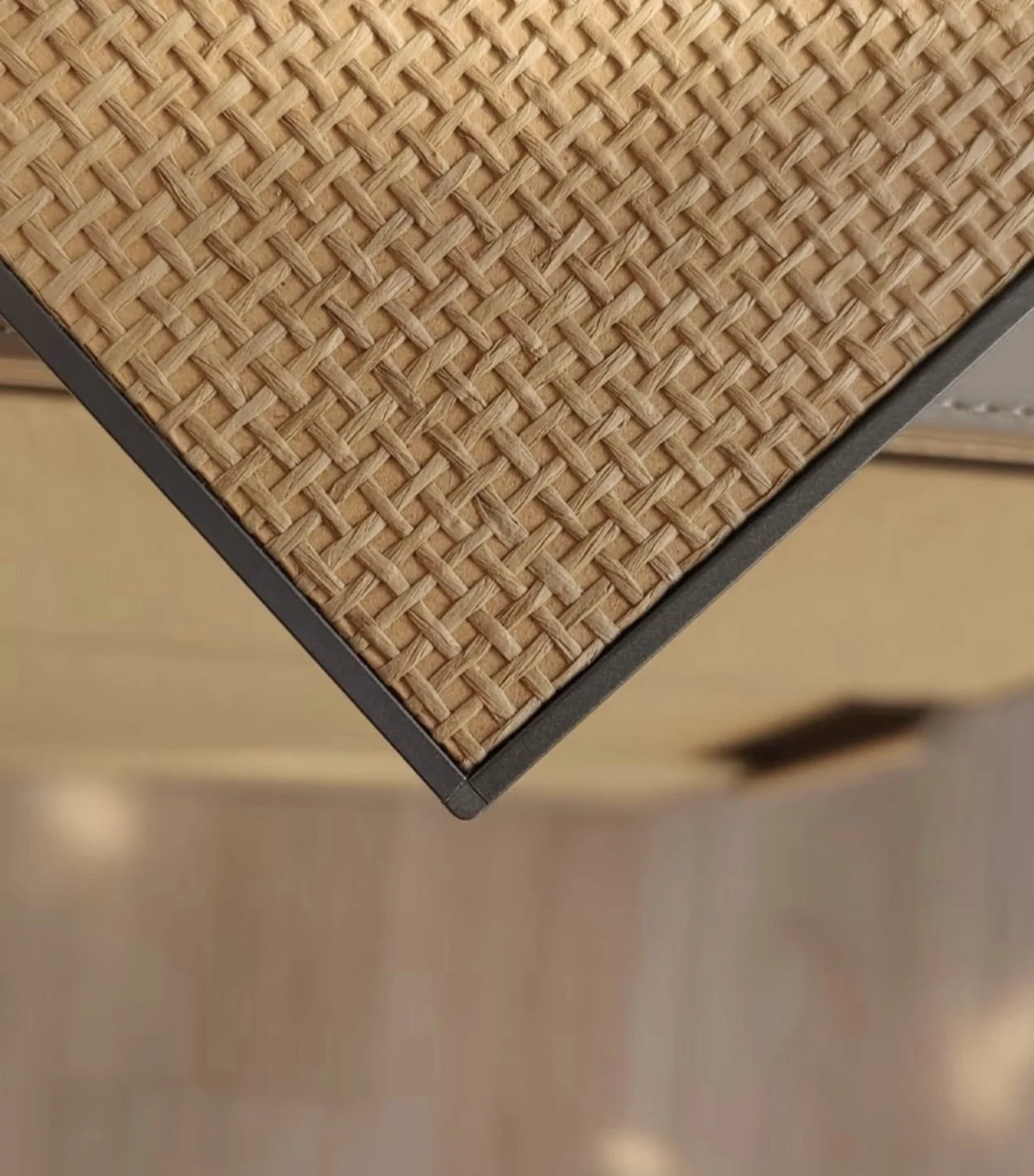 Detail of a cabinet front faced with tan jute wallcovering within a framed edge