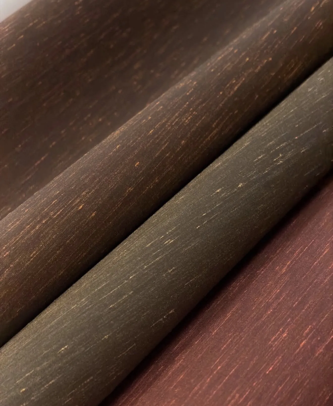 Rolled silk wallcoverings in deep brown, olive and wine tones with copper flecks catching the light